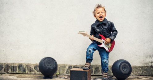 Image of child playing a rock guitar suggesting tecruitment of rockstars: How to hire the best people.