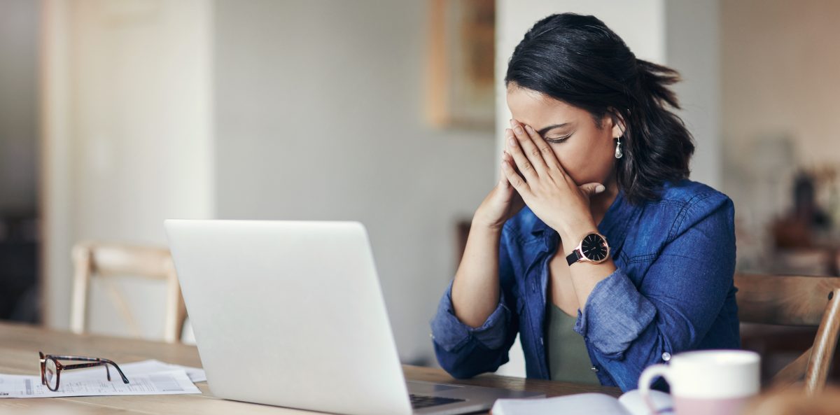 Woman at desk looking stressed by her computer