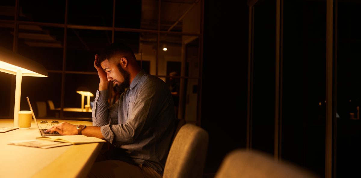 A nonprofit leader works late at a desk, underscoring the weight of difficult leadership decisions.